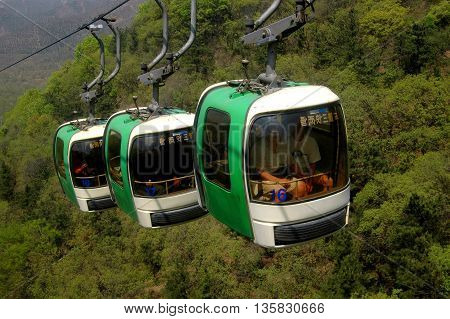 Badaling China - May 2 2005: Three cable car gondolas whisk tourists up to the Badaling district section of the Great Wall of China