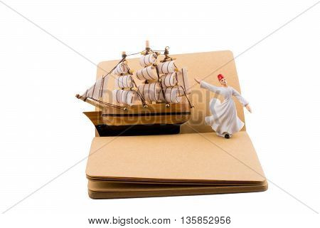 Sufi Dervish and a ship on a notebook on white background