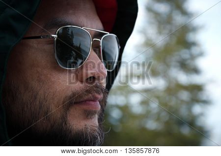 asian man under hood with sunglassess outdoor