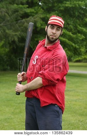 OLD BETHPAGE, NEW YORK - MAY 22, 2016: Baseball player in 19th century vintage uniform during old style base ball play following the rules and customs from 1864 in Old Bethpage Village Restoration