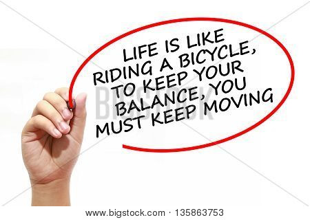Man writing LIFE IS LIKE RIDING A BICYCLETO KEEP YOUR BALANCEYOU MUST KEEP MOVING with marker on transparent wipe board.