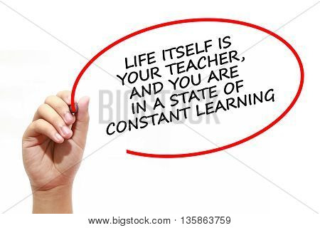 Man writing LIFE ITSELF IS YOUR TEACHER AND YOU ARE IN A STATE OF CONSTANT LEARNING with marker on transparent wipe board.