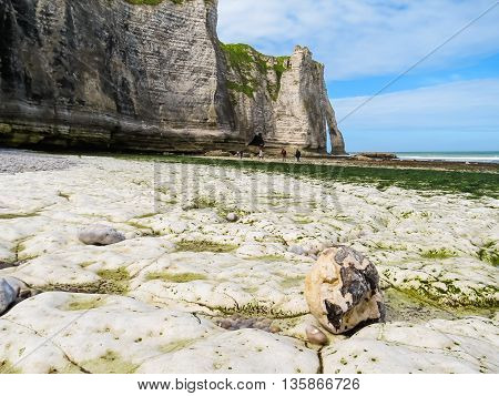 The coast of English Channel in outflow and cliff Porte d'Aval as background. Etretat, Normandy, France