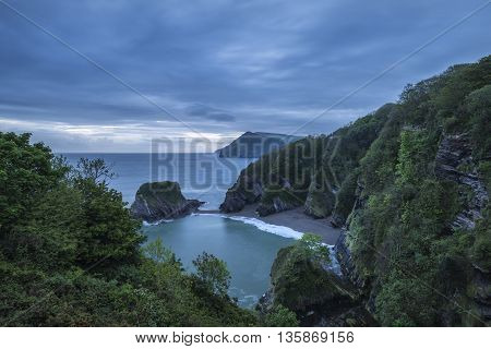 Beautiful Dramatic Sunrise Landsape Image Of Small Secluded Cove At Combe Martin Bay