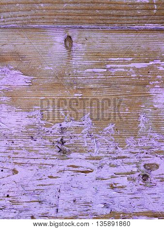 The surface of a wooden board with traces of old pink paint