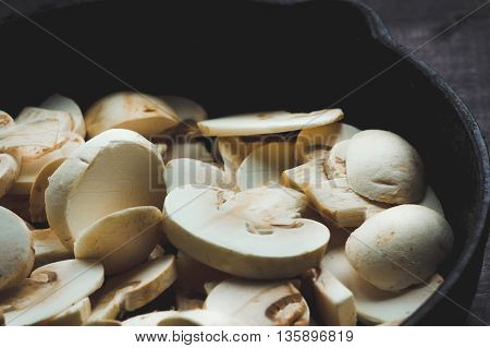 hampignon mushrooms in a cast iron frying pan before cooking