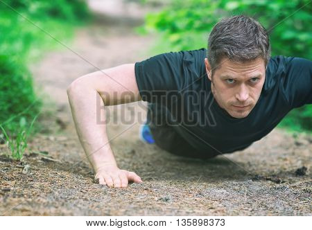 Handsome Man Doing Push-ups In The Forest.