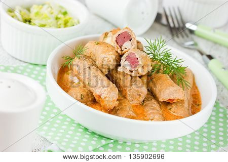 Meat fingers of pork fillet with ham stuffing in sauce traditional Russian cuisine selective focus