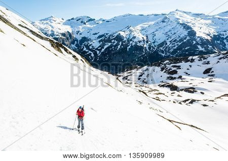 Female skier ascending a mountain slope. Ski touring in Malta valley, Austria.