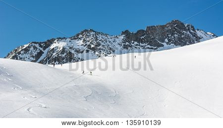 Snow covered slope with ski tracks. Enjoying off piste skiing.