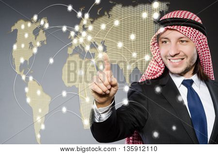 Arab man pressing dots on world map in global communication conc