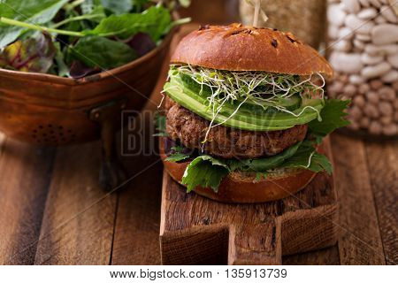 Grilled vegan bean burger with avocado, salad and cucumber