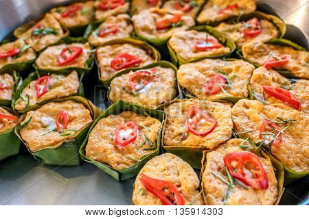 Thai steamed curry fish in banana leaf cups decorated with red chilli (Hor Mok Pla)