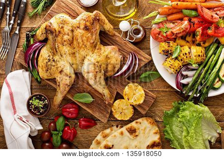 Grilled vegetables and chicken on wooden table overhead shot