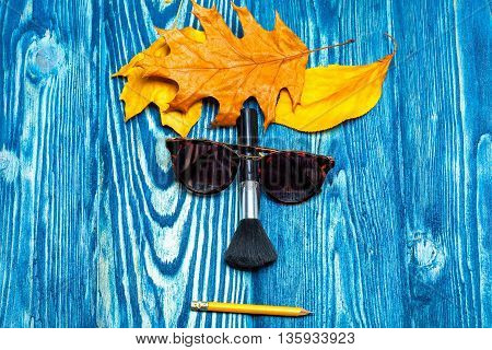 Glasses Brush Pencil And Leaves On Wood