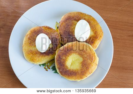 Grandma's curd pancakes with their hands with scented cream