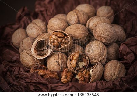 Cracked stack of walnuts on brown paper