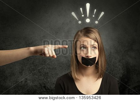 Caucasian hand pointing at female employee with drawn exclamation marks above her head