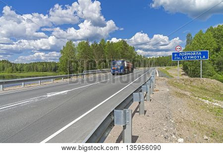 RUSSIA KARELIA INTERSECTION OF LOYMOYLA RIVER AND FEDERAL HIGHWAY A121 - JUNE 15 2016: Federal Highway A121. Tanker truck on the bridge over the river Loymoyla. June. South Karelia. Russia.
