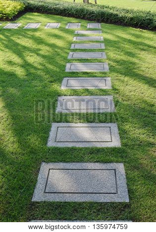 L shape of gravel pathway on green field as background