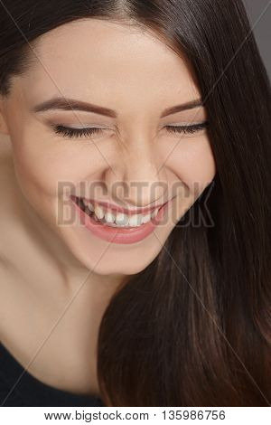 Closeup portrait of happy smiling beautiful woman with long brownhair posing in studio. Modern hairstyle concept.