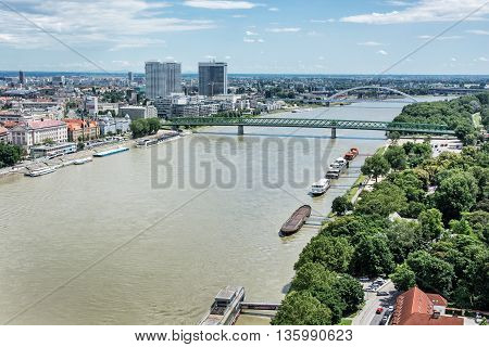 Bridges over the Danube river in Bratislava city Slovak republic. Docks scene. Old bridge and Apollo bridge. Ship transportation. High-rise buildings. Travel destination.