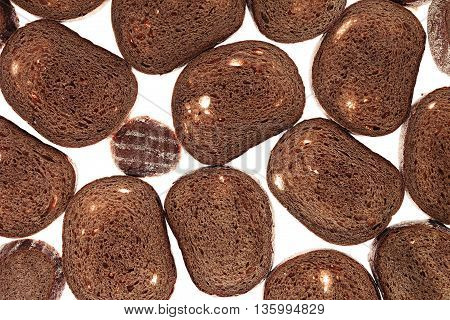 Slices of black rye bread on a white background. Food background. Pattern.