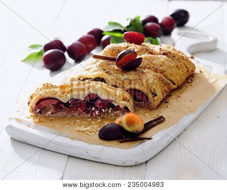 Fresh Plums And Ricotta Strudel Sprinkled With Brown Sugar And Cinnamon.