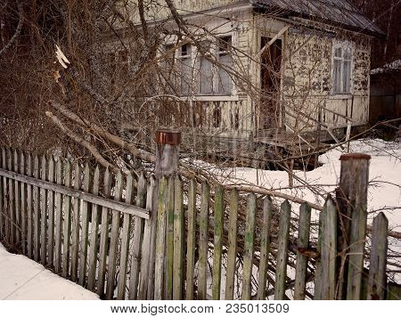Abandoned Old Wooden House Behind The Fence And Thicket, Filtered Image
