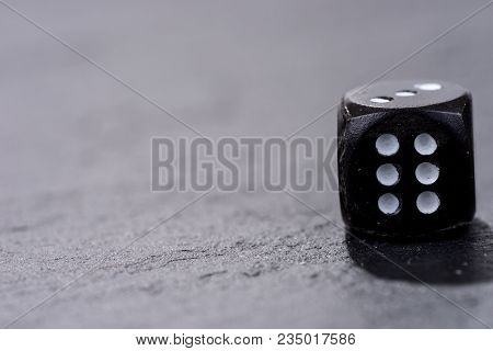 Single Black Dice On Black Background. Six Side Cube With White Dots