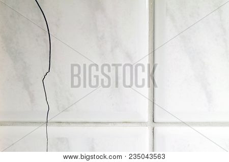 Cracked Tiles On The Bathroom Wall Need Repair. Possible Sign Of Water Damage. Horizontal Image Of B