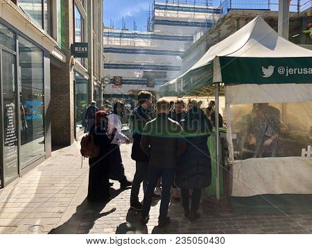 SOHO, LONDON - APRIL 5, 2018: Pedestrians at a market selling food, flowers, fruit and vegetables on Berwick Street in Soho, London, UK.