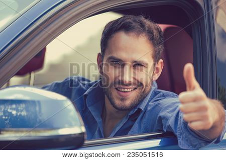 Man Driver Happy Smiling Showing Thumbs Up Driving Sports Blue Car On A City Street Outside Backgrou