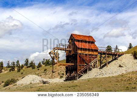 Old Abandoned Mine Works And Headframe Building On This Hillside In Colorado.