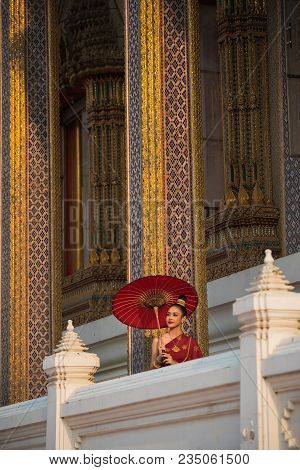 Beautiful Women In Red Tradition Breast Cloth Dress With Red Umbrella Stand  In Temple.