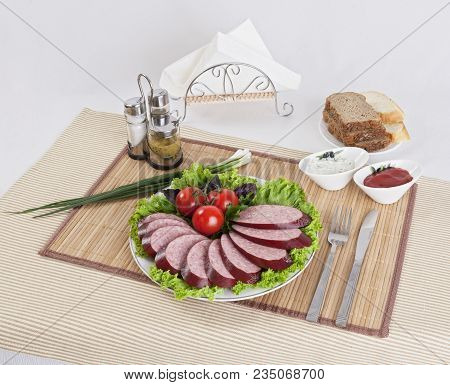 Smoked Sausage With Tomatoes And Lettuce Leaves On A Plate.  Can Be Used In Advertising And In The D