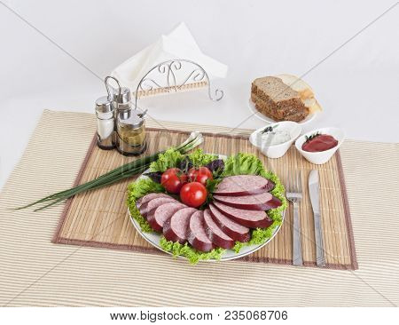 Smoked Sausage With Tomatoes And Lettuce Leaves On A Plate.  Can Be Used In Advertising And In The D