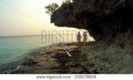 Love Couple Strolls Along The Shore At Sunset. The Beautiful Nature Of The Philippines. Aerial View