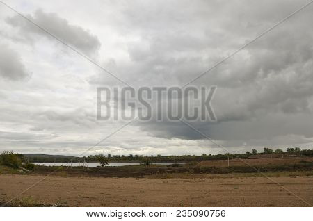 Heavy Grey Clouds In The Cold Autumn Sky Over Rivers, Fields, Forests And Mountains
