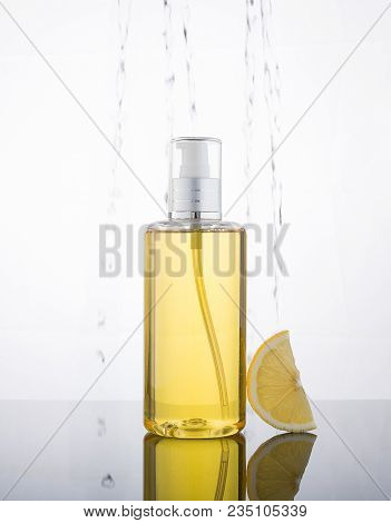 High Key Photography Liquid Jel Bottle And Lemon With Droplet In The Background.