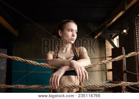 Picture Of Attractive Muscular Young Caucasian Female Posing Indoors In Boxing Ring, Having Rest Aft