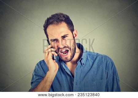 Closeup Angry Man, Mad Worker, Pissed Off Employee Shouting While On Phone Isolated On Grey Wall Bac