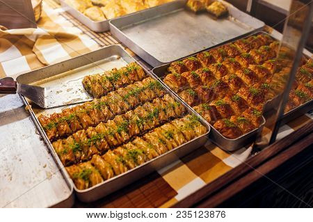 Assortment Of Turkish Baklava With Pistachio On Cafe Showcase. Sweet Baklawa On Tray In Store. Arabi