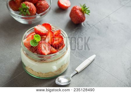 Strawberry Cheesecake In Glass Jar With Fresh Strawberries And Cream Cheese  On Grey Concrete Backgr