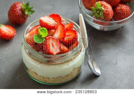Strawberry Cheesecake In Glass Jar With Fresh Strawberries And Cream Cheese  On Grey Concrete Backgr
