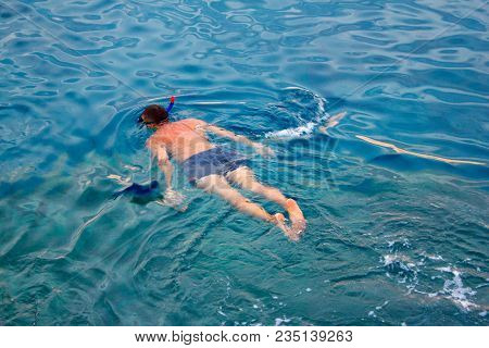 A Man In A Diving Suit Swims In The Sea, Top View. Activities On The Water