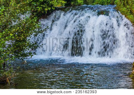Little tourist town on the river Korana - Slunj. Cascade waterfalls are lit by sunset rays. The concept of ecological, pedestrian and photo tourism