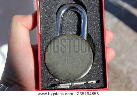 Man Holds An Old Lock In His Hand