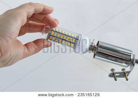 Close-up Of Human Hand Is Screwing Corn Shaped Led Lamp Into Lampholder Of  Household Ceiling-mounte