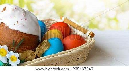 Homemade Easter Cake And Easter Eggs In Wicker Basket On White Wooden Table. Easter Background.